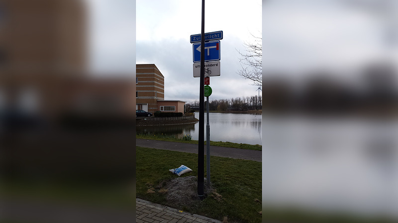 Zicht op straatnaambordje Zuiderlicht geblokkeerd door lantaarnpaal