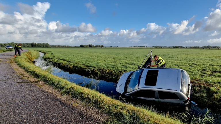 Verlaten auto in sloot langs Bergense Schapenlaan; bumper ligt verderop