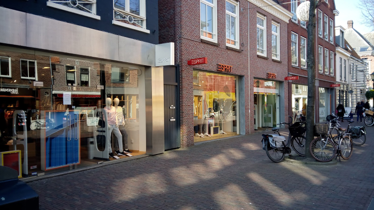 Winkelstraat met diverse Esprit-winkels en fietsen langs de weg.