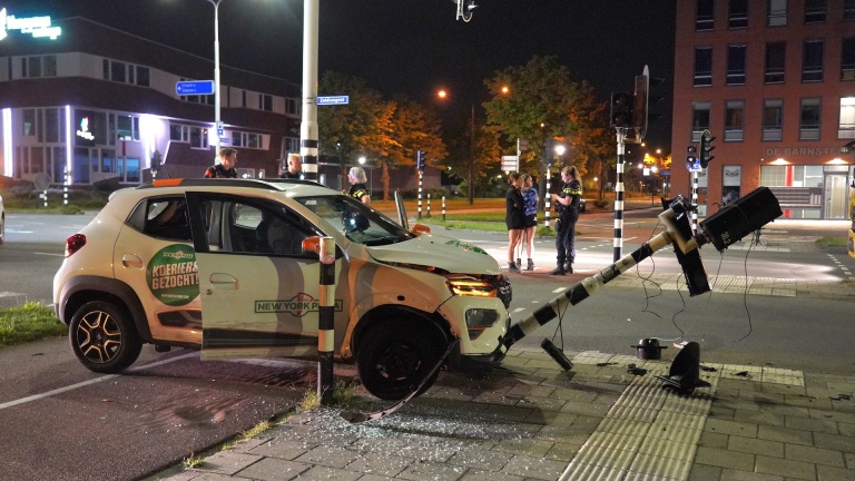 Auto van New York Pizza bezorgdienst gebotst tegen verkeerslicht, politie onderzoekt ongeval, avondscène.