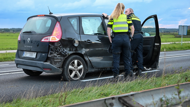 Verkeersongeluk met een beschadigde auto en twee politieagenten.