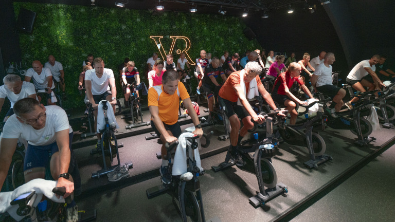 Mensen nemen deel aan een spinningles in een sportschool.