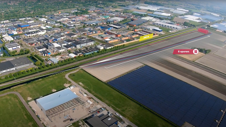 Luchtfoto van een industriegebied met een gemarkeerd spoorweggebied van 340 meter en een zonnepark.