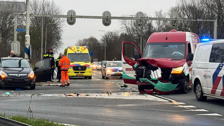 Verkeersongeval met meerdere voertuigen op een kruispunt, met politie en ambulance ter plaatse.