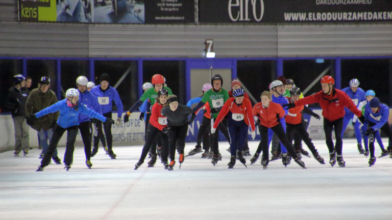 Schaatsers op een indoor schaatsbaan tijdens een wedstrijd of training.