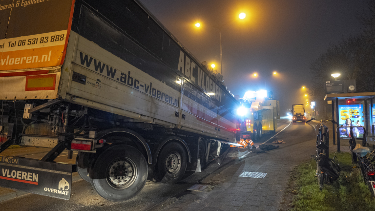 Containerwagen van ABC Vloeren geparkeerd langs een verlichte straat, met fiets en bushokje zichtbaar.