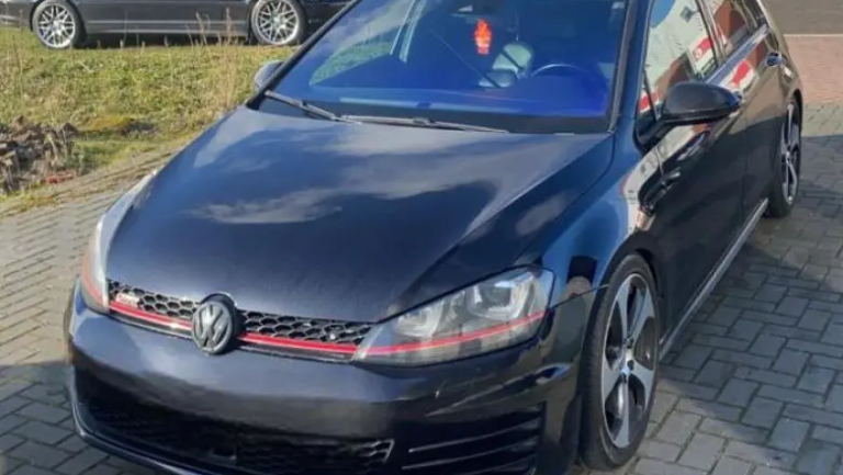 Zwarte Volkswagen Golf GTI geparkeerd op een oprijlaan.