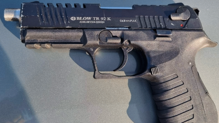 Een zwart pistool van het merk Blow TR 92 K met kaliber 9 mm P.A.K., liggend op een oppervlak.
