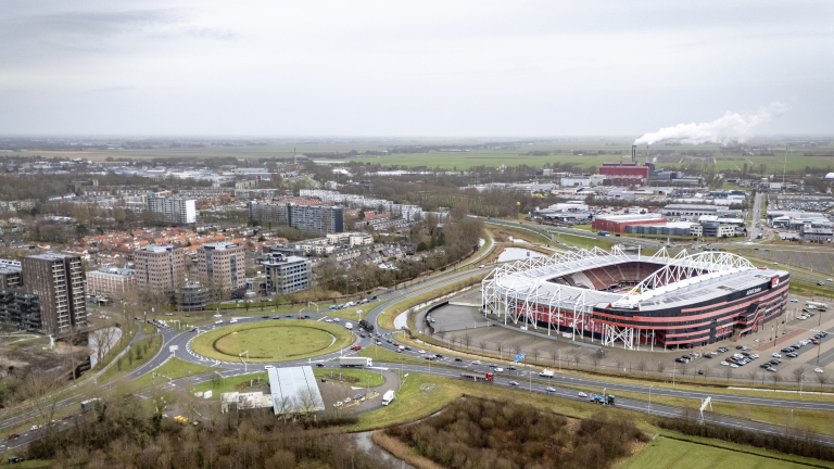 Luchtfoto van een stadion en omliggende bebouwing in een stad.