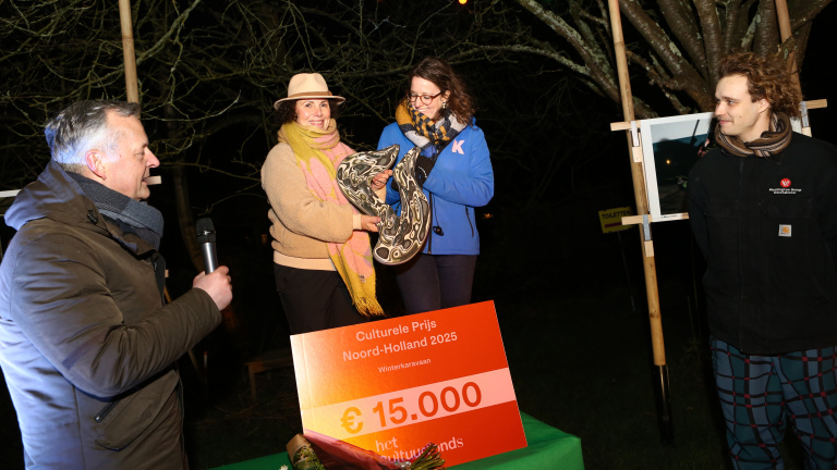 Vier mensen staan bij een bord met de tekst "Culturele Prijs Noord-Holland 2025" en een bedrag van €15.000.