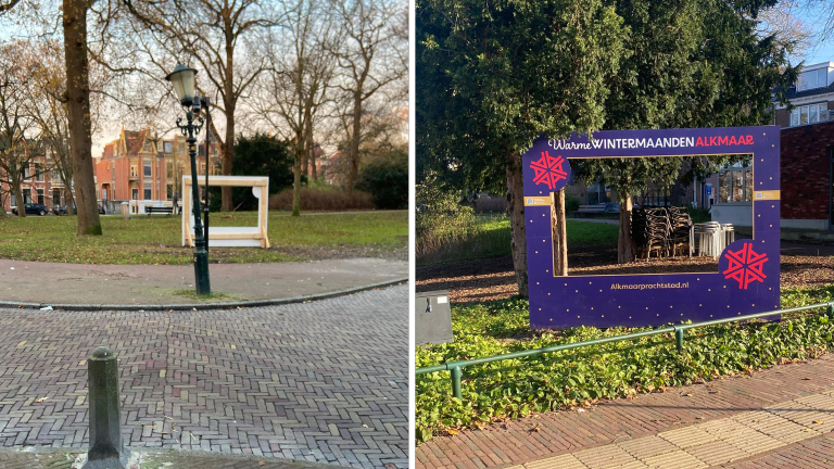 Twee fotolijsten in een park, links een eenvoudige houten lijst en rechts een versierde lijst met tekst "Warme Wintermaanden Alkmaar", omgeven door bomen en gebouwen.