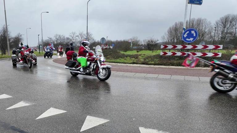 Motorrijders verkleed als kerstmannen rijden een rotonde op.