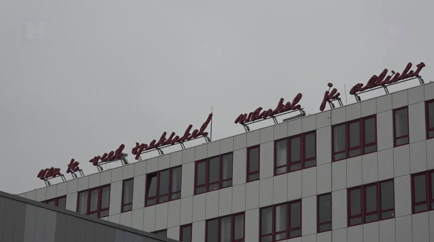 Gebouw met de tekst "Als ik te veel speel, word je verliefd" op het dak.