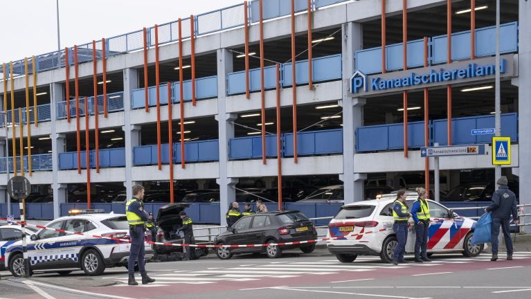 Parkeergarage Kanaalschiereiland in Alkmaar met politie- en handhavingsvoertuigen en agenten die een gebied afzetten met rood-wit lint.