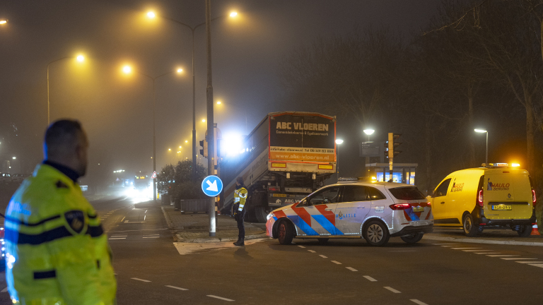 Politieagenten en voertuigen bij een verkeersongeluk in de nacht met mistige omstandigheden. Er is een vrachtwagen met "ABC Vloeren" en een gele bestelwagen van "Maulo Berging".