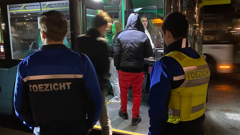 Opstapplaatsen met toezichthouders in een bus.