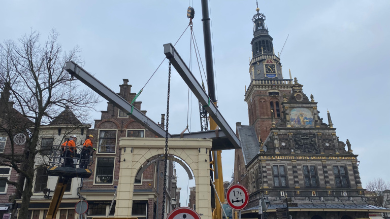 Bouwplaats met kraan en stalen constructie voor historische gebouwen in een stadscentrum.