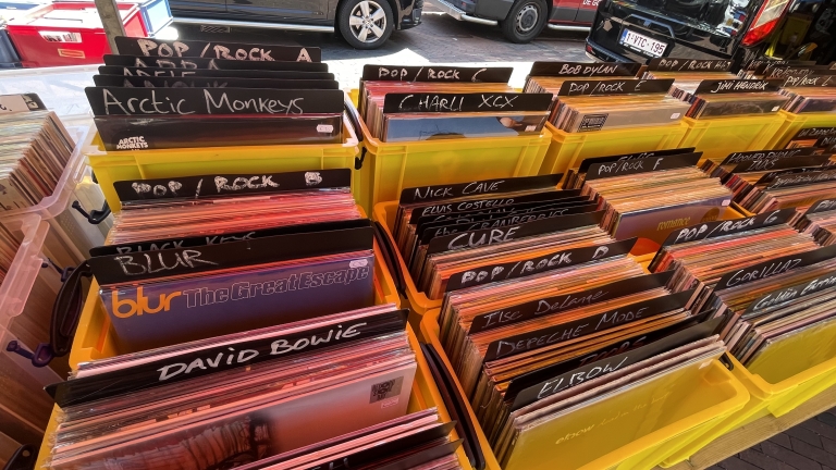 Kratten met vinylplaten georganiseerd op artiest in een platenmarkt.