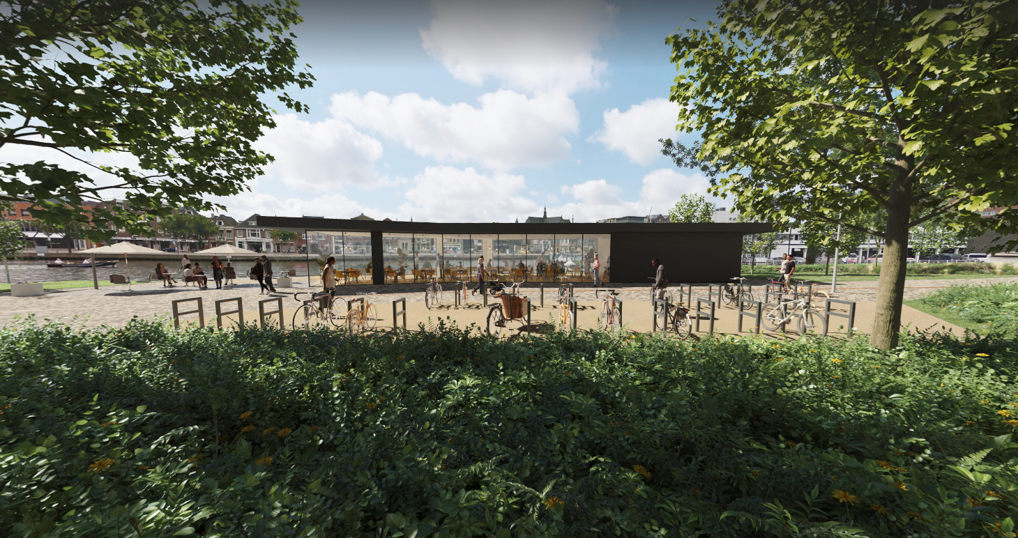 Buitenaanzicht van een modern gebouw met glazen gevels en een terras met tafels en stoelen, omgeven door fietsenrekken en groenvoorzieningen. Er zijn mensen die ontspannen en fietsen geparkeerd achterlaten. Op de achtergrond is een waterweg met boten zichtbaar.