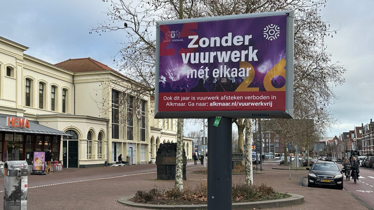 Reclamebord met tekst over vuurwerkverbod in Alkmaar, gelegen op een plein naast een HEMA-winkel.