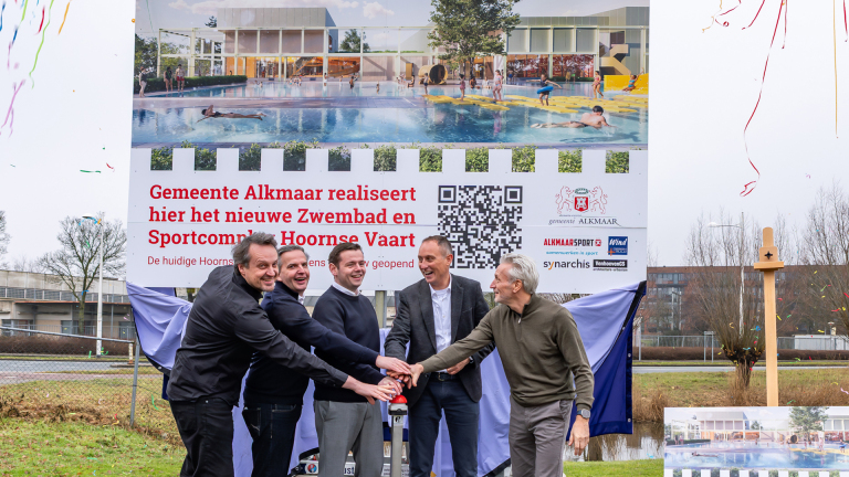 Vijf mannen drukken op een knop voor een bord dat de bouw van een nieuw zwembad en sportcomplex in Alkmaar aankondigt.