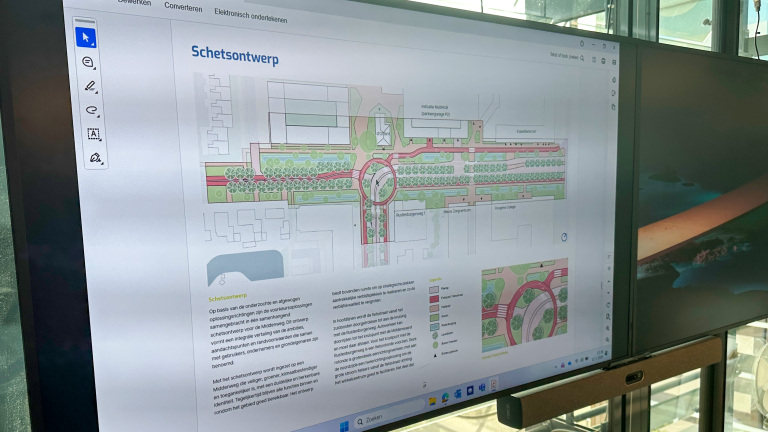 Een scherm toont een landschapsarchitectuurschets met wegen, groenstroken en tekst met het woord "Schetsontwerp" bovenaan.