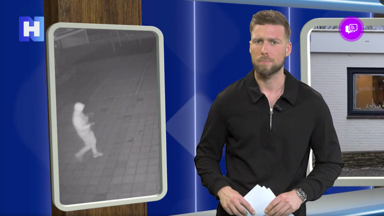 Man in zwart shirt presenteert voor een scherm, met links een beveiligingsbeeld van een persoon op straat.