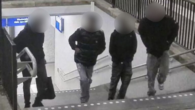 Vier silhouetten op een trap bij een ondergrondse doorgang, met gezichten onherkenbaar gemaakt.