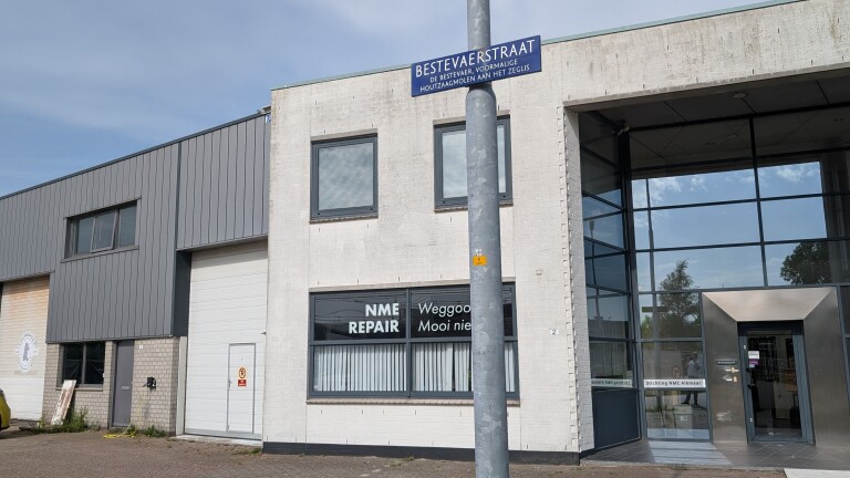 Bedrijfspand aan de Bestevaerstraat, met zichtbare borden van "NME Repair" en "Stichting NME Alkmaar".