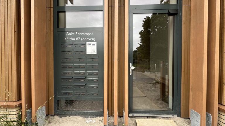 Entree met brievenbussen en intercom, met tekst “Anke Servaespad 45 t/m 87 (oneven)” naast glazen deur