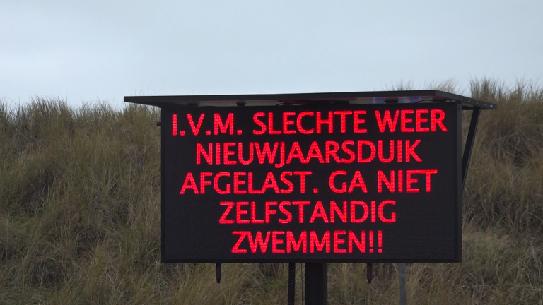 Elektronisch bord met de tekst: "I.V.M. SLECHTE WEER NIEUWJAARSDUIK AFGELAST. GA NIET ZELFSTANDIG ZWEMMEN!!"