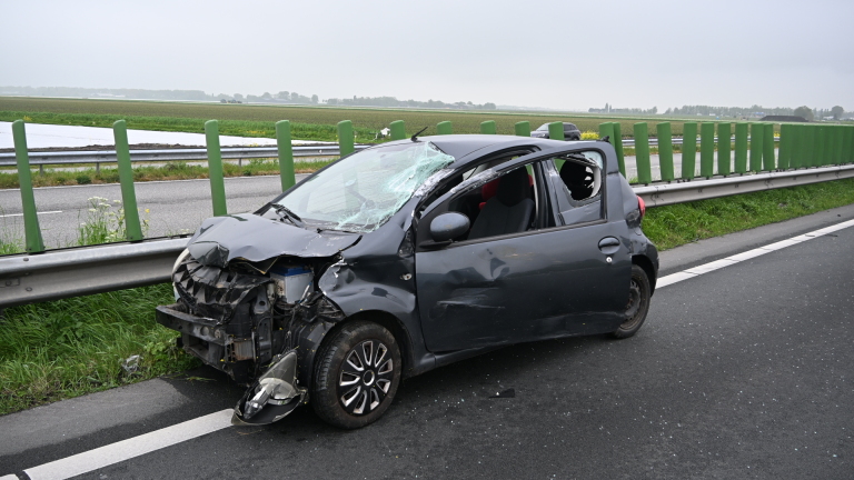 Beschadigde auto met ingedeukte voorkant op een gele sleepwagen.
