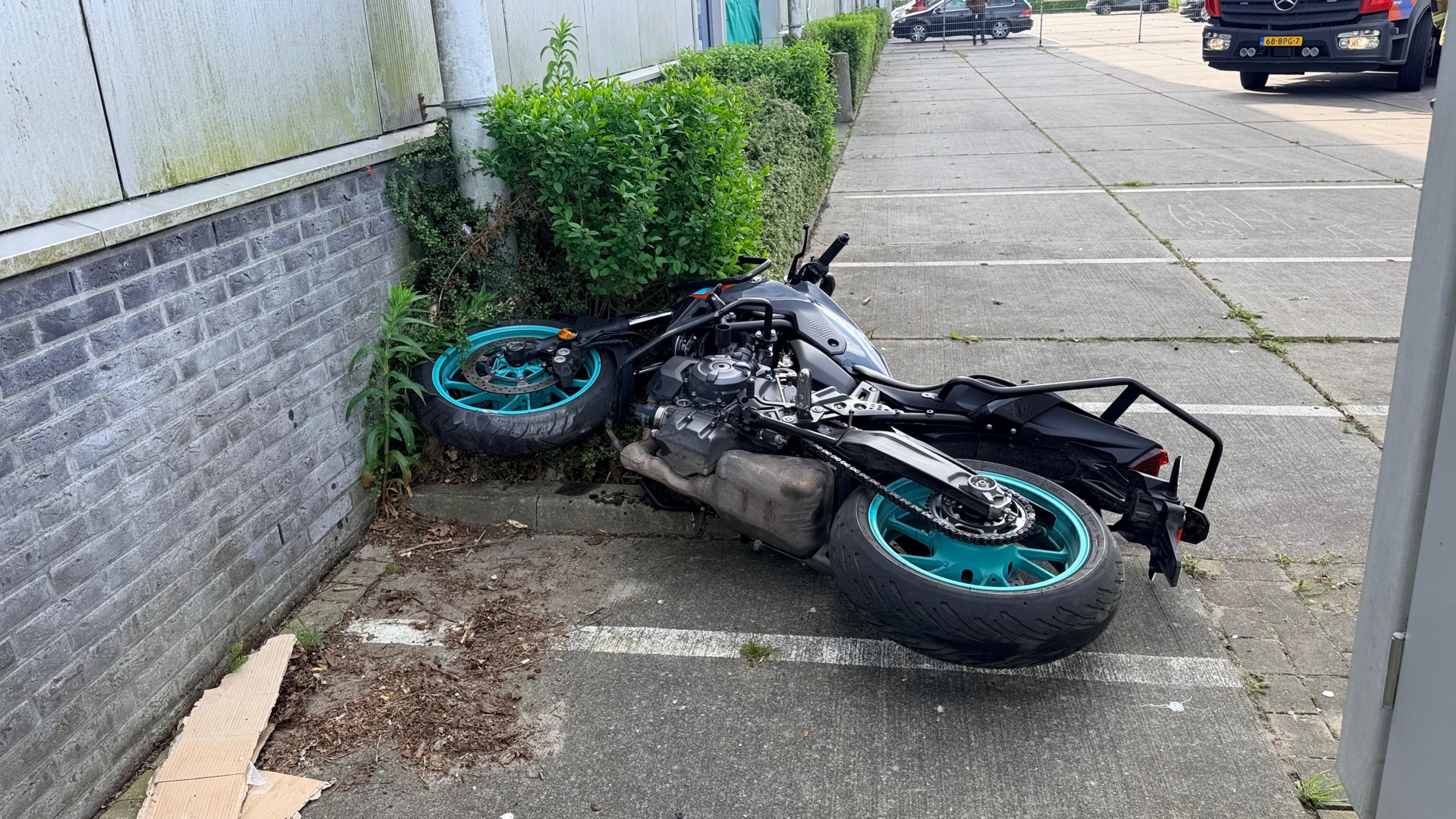 Politie, brandweer en ambulance staan buiten een groot gebouw geparkeerd; agenten en brandweerlieden zijn actief.