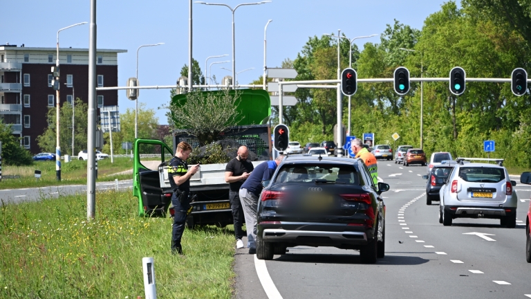 Politiecontrole onder viaduct met agenten in reflecterende kleding, een politie-motorfiets en passerende auto's.
