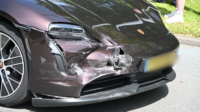 Auto met aanzienlijke schade aan de voorkant, met gebarsten en gedeukte bumper.