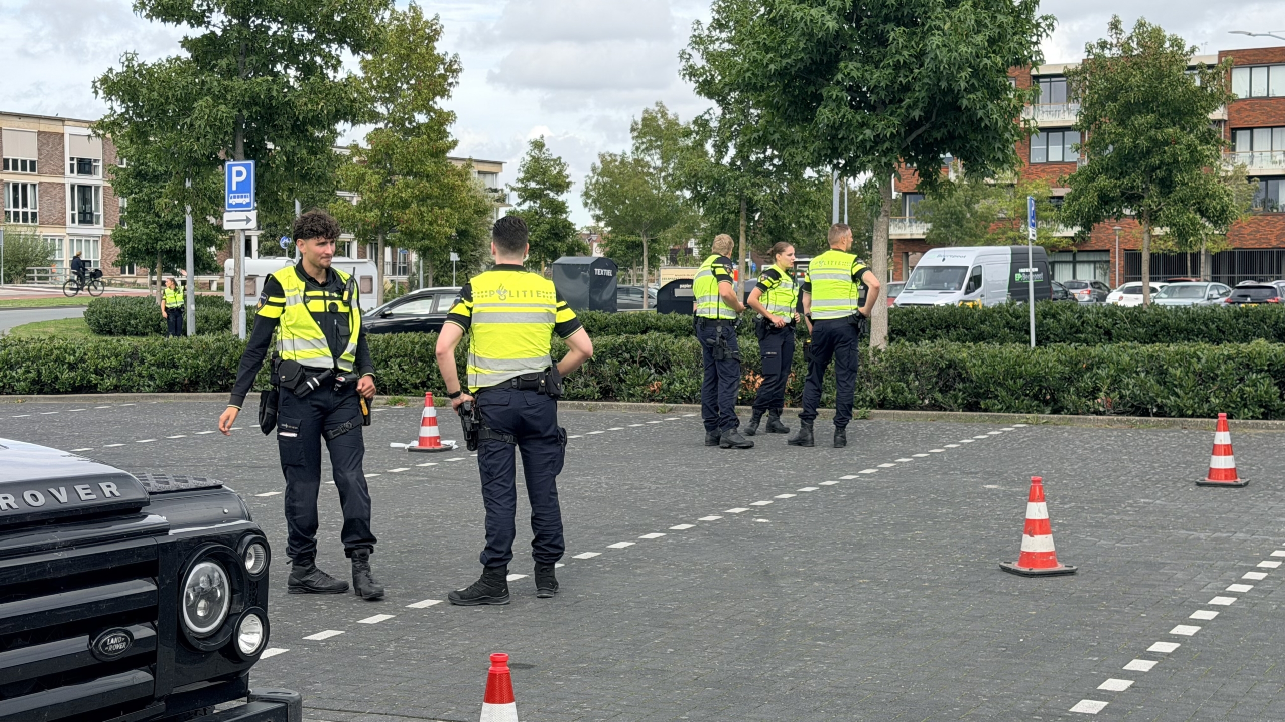 Politieagent op een scooter op een testbank, met politievoertuigen en een caravan op de achtergrond