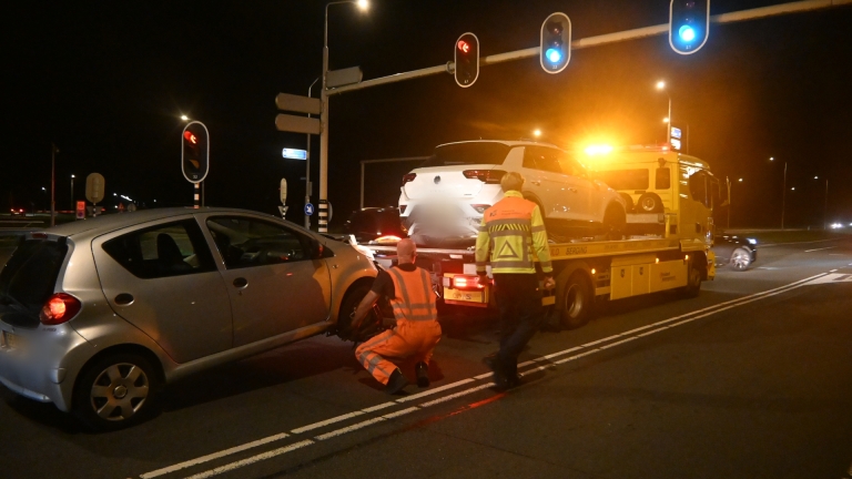 Kop-staartbotsing in het donker, met een grijze auto die achterop een witte auto is gereden