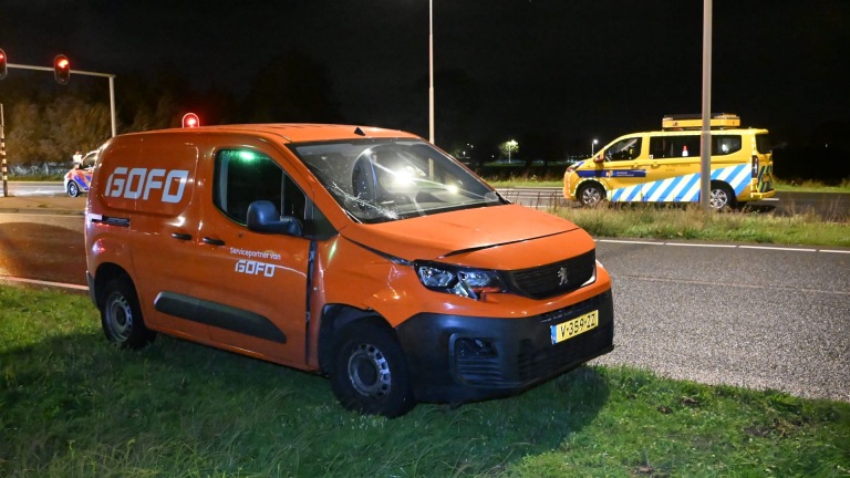 Politie en hulpverleners onderzoeken ’s nachts een ongevalslocatie langs de weg, met een omgevallen fiets in het gras