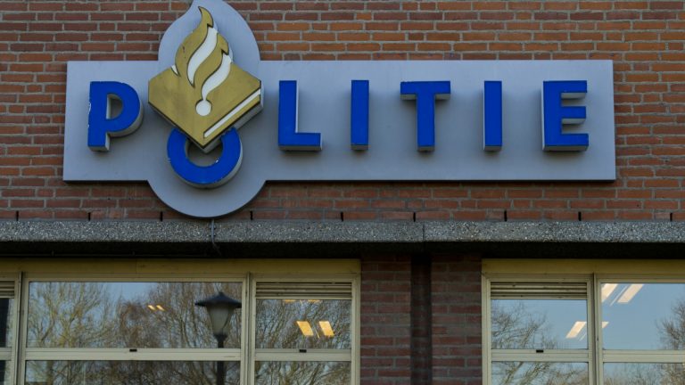 Bord met opschrift "POLITIE" op een bakstenen muur.