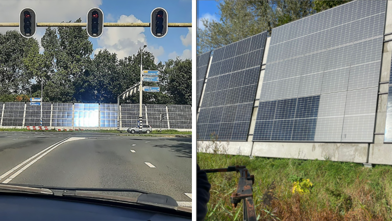 Zonnepanelen bij een kruispunt met verkeerslichten, omgeven door bomen en gras.