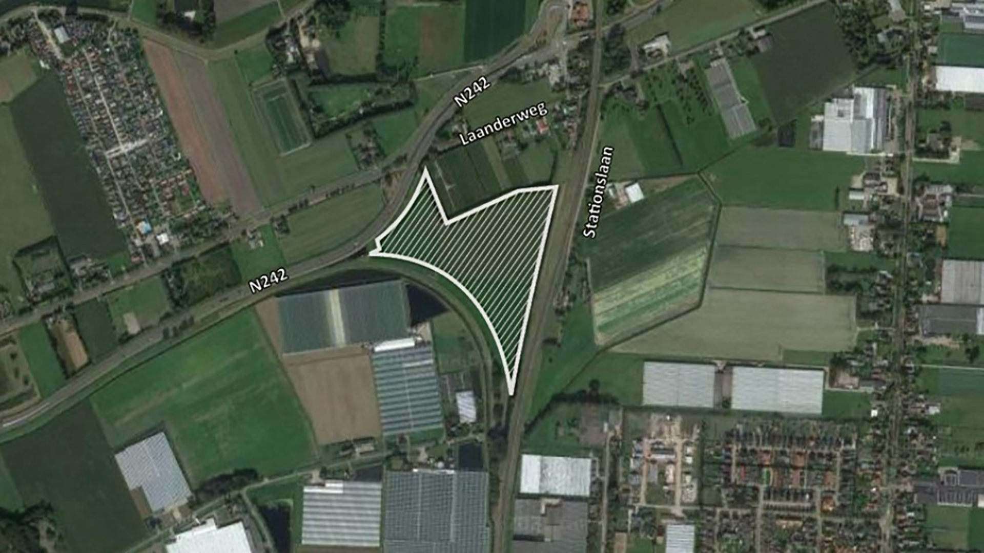 Satellietbeeld van een gebied bij Laanderweg en Stationslaan, begrensd door wegen N242 en omliggende landbouwgronden.