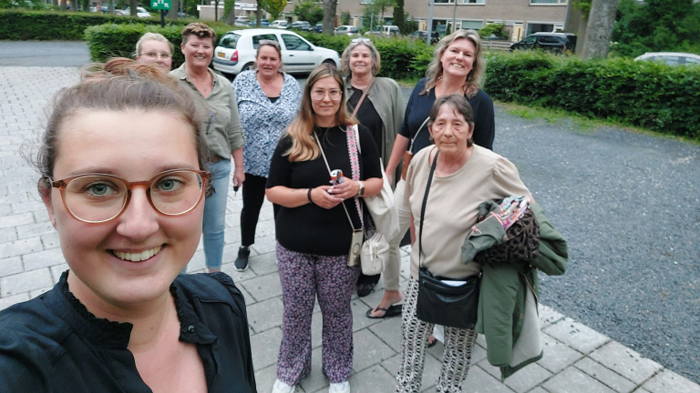 Groep vrouwen die buiten samen lacht voor een foto. Kledingbank Noord-Holland Noord bestuur en vrijwilligers na verkoopdag in het Alkmaarse wijkcentrum De Alkenhorst