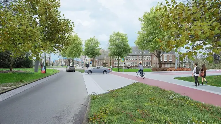 Kruispunt met auto’s, fietser en voetgangers langs een rood fietspad bij bomen en een schoolgebouw