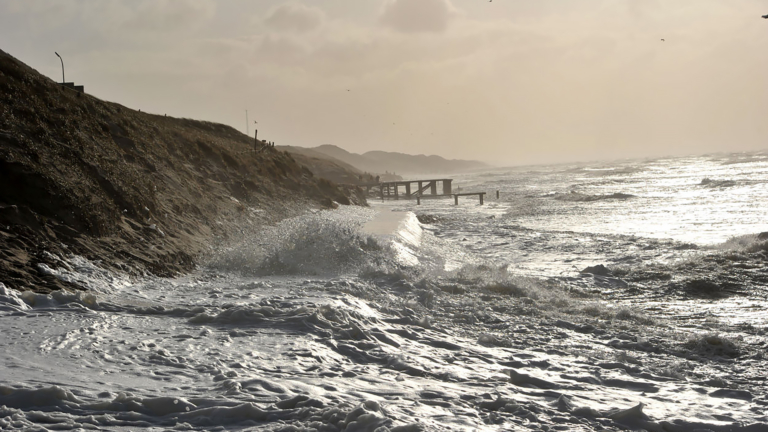 Zandwal voor strandopgang Egmond aan Zee vanwege vloed en storm Pia